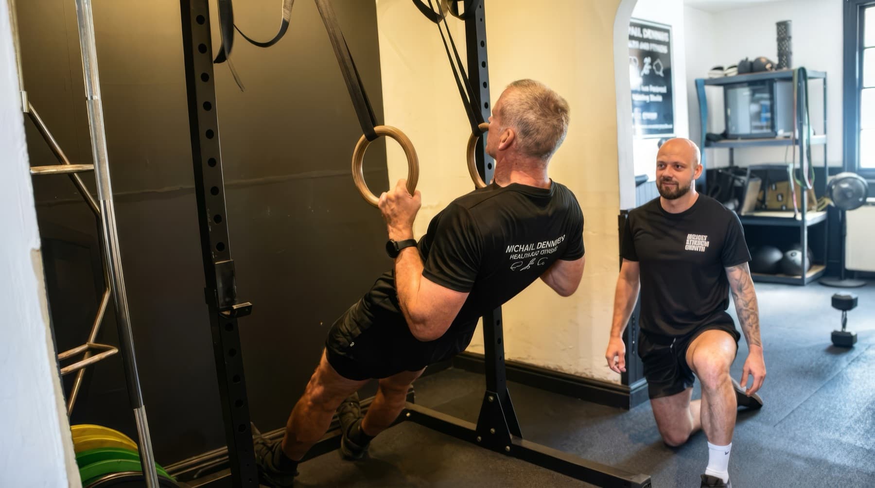 Michael Dennison coaching a client through ring rows in his private one-to-one training studio