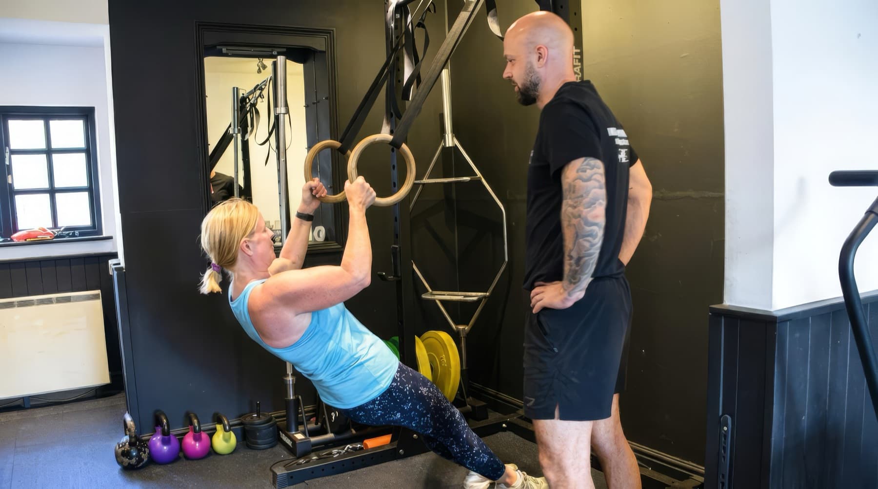 Michael Dennison coaching a client through a ring row in his private studio