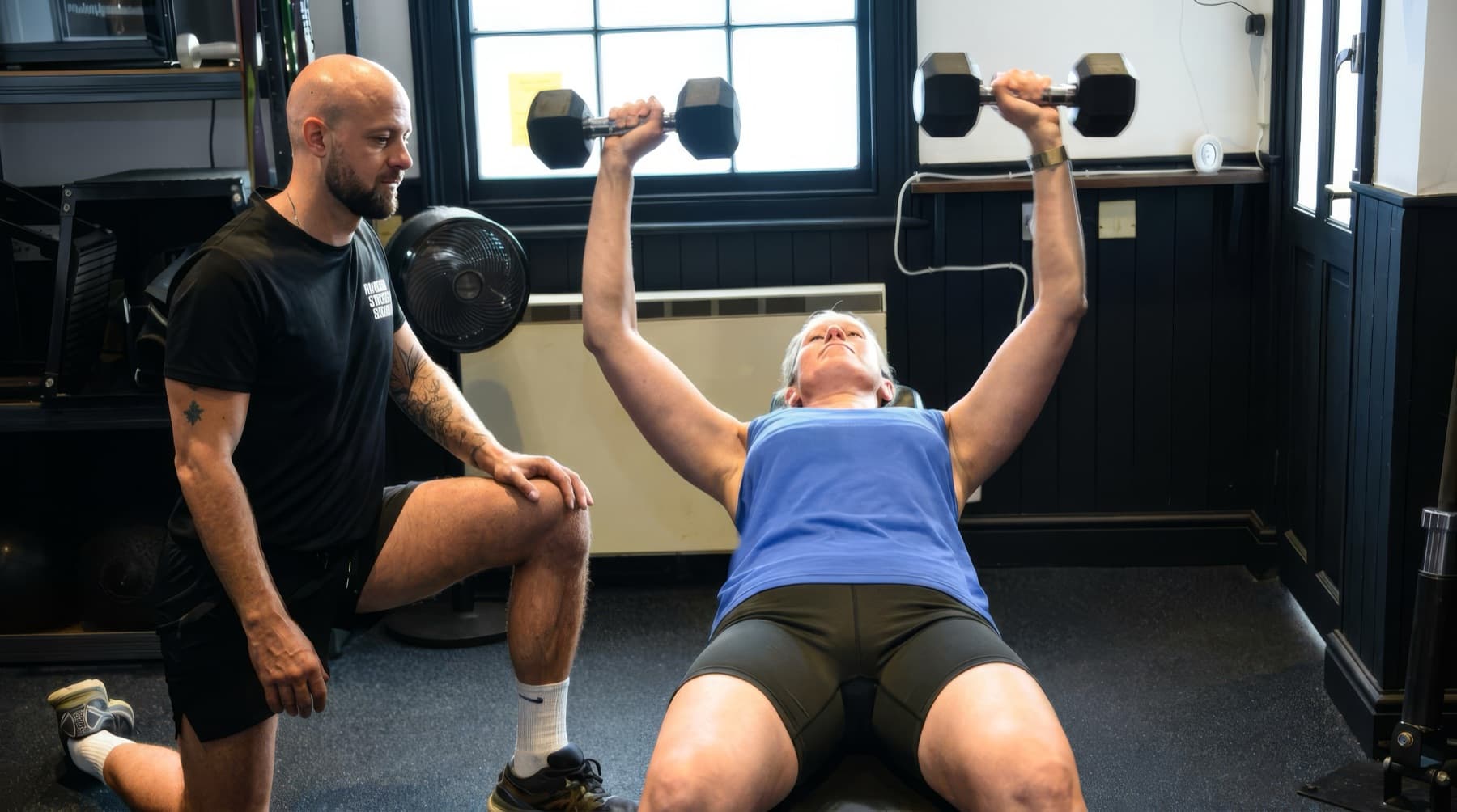 Michael Dennison coaching a client through a dumbbell press